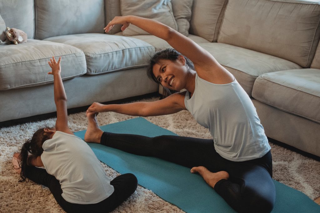 A mother and daughter practice a yoga stretch