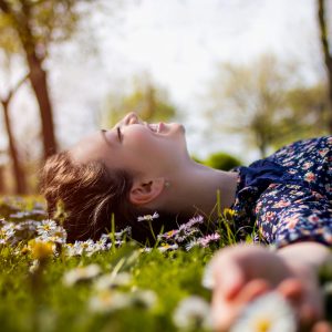Pretty young teenage girl laying on a grass